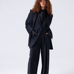 Person wearing a black suit on a white background