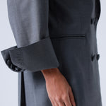 Gray blazer with a hand visible on a white background