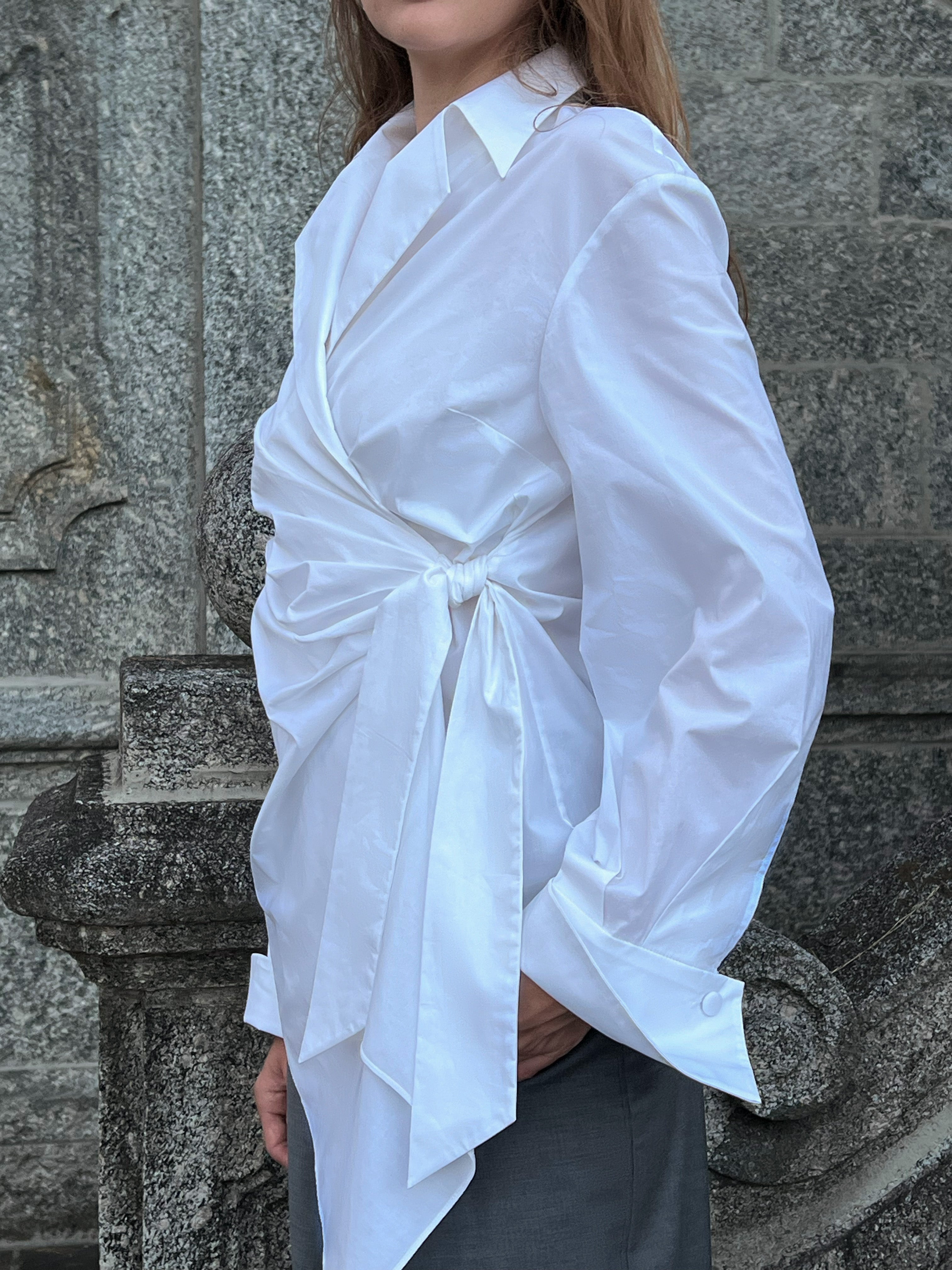 Belted white cotton front draped Italian shirt worn by a model, showcasing the tied waist detail