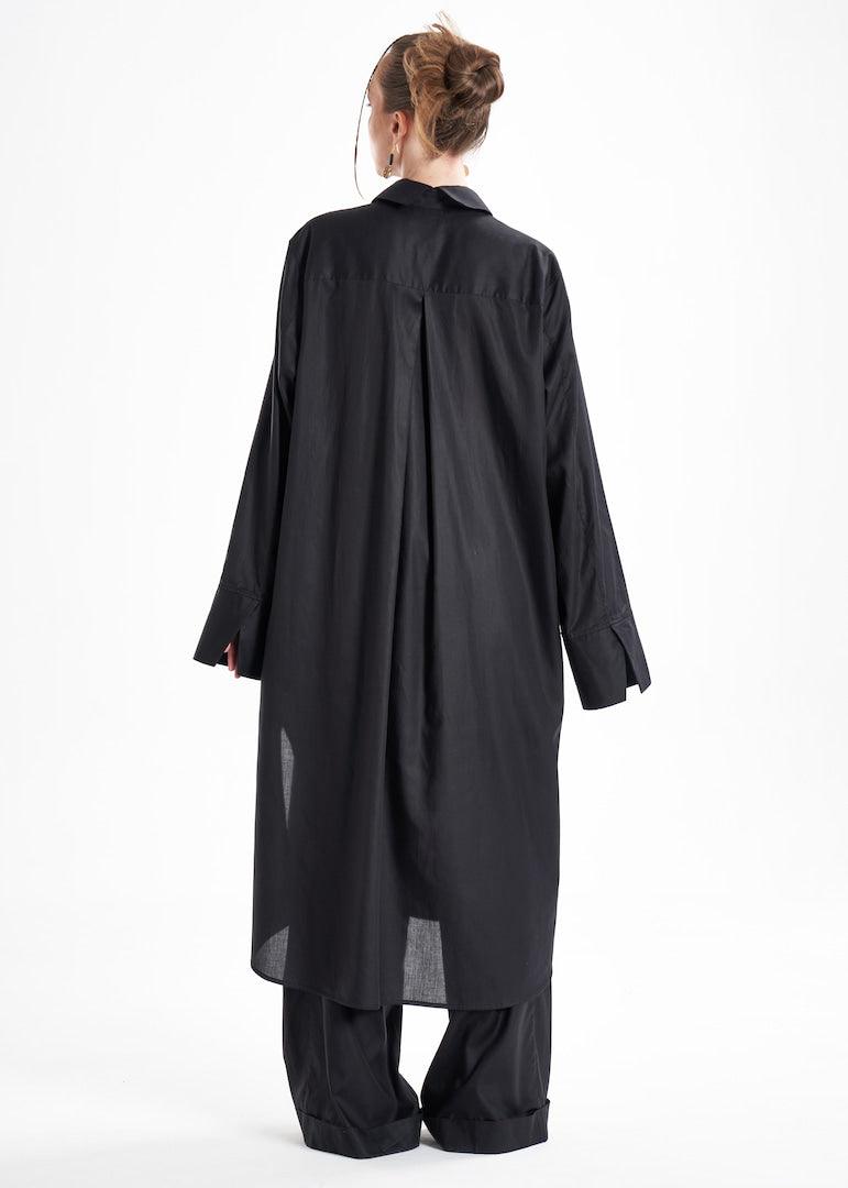 Black long shirt dress worn by a model from the back, highlighting the flowing silhouette and oversized sleeves