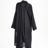 Black long shirt dress worn by a model from the back, highlighting the flowing silhouette and oversized sleeves