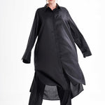 Black long shirt dress worn by a model in motion, showcasing the flowing silhouette and relaxed fit
