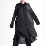 Black long shirt dress worn by a model in motion, showcasing the flowing silhouette and relaxed fit