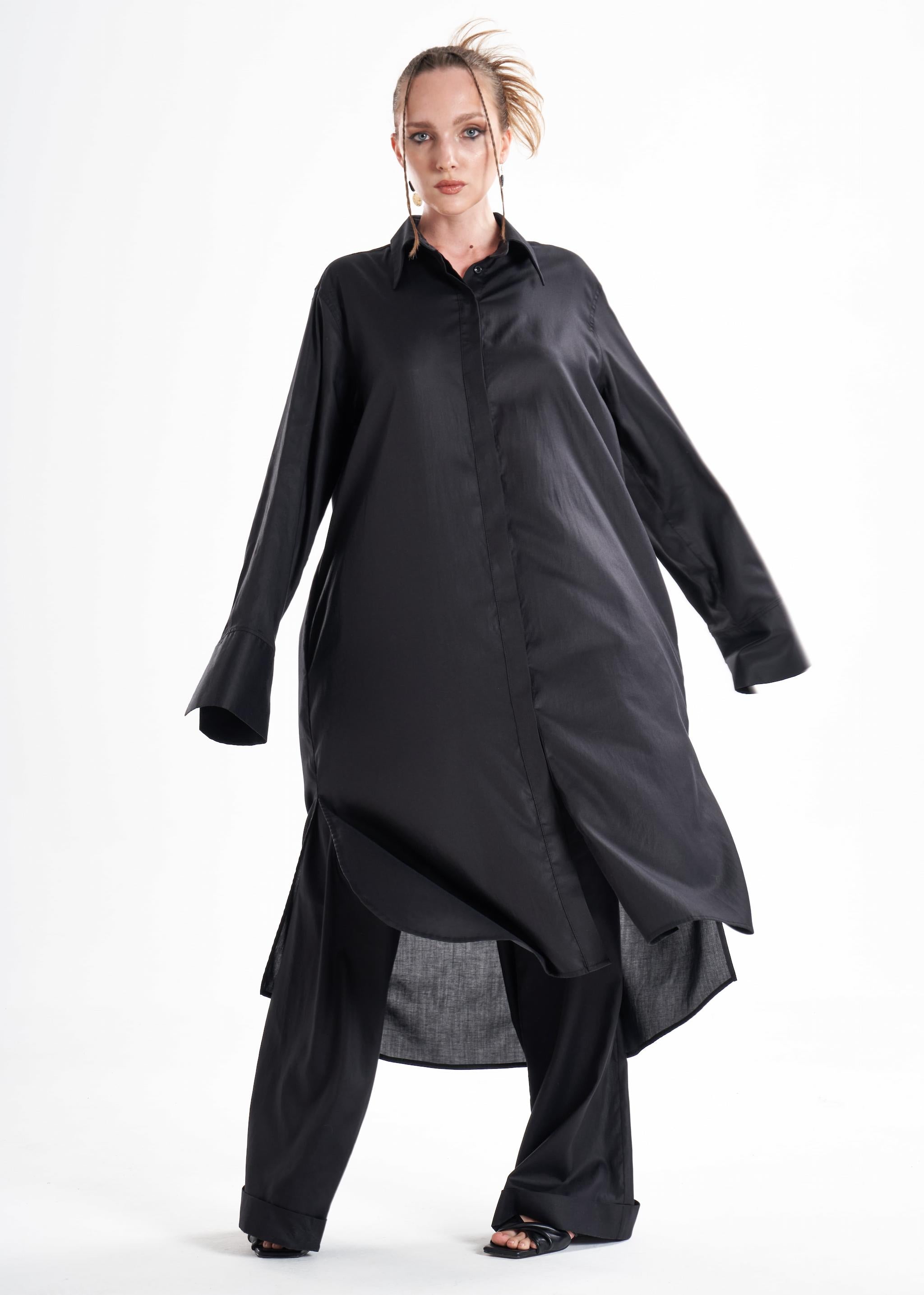 Black long shirt dress worn by a model in motion, showcasing the flowing silhouette and relaxed fit