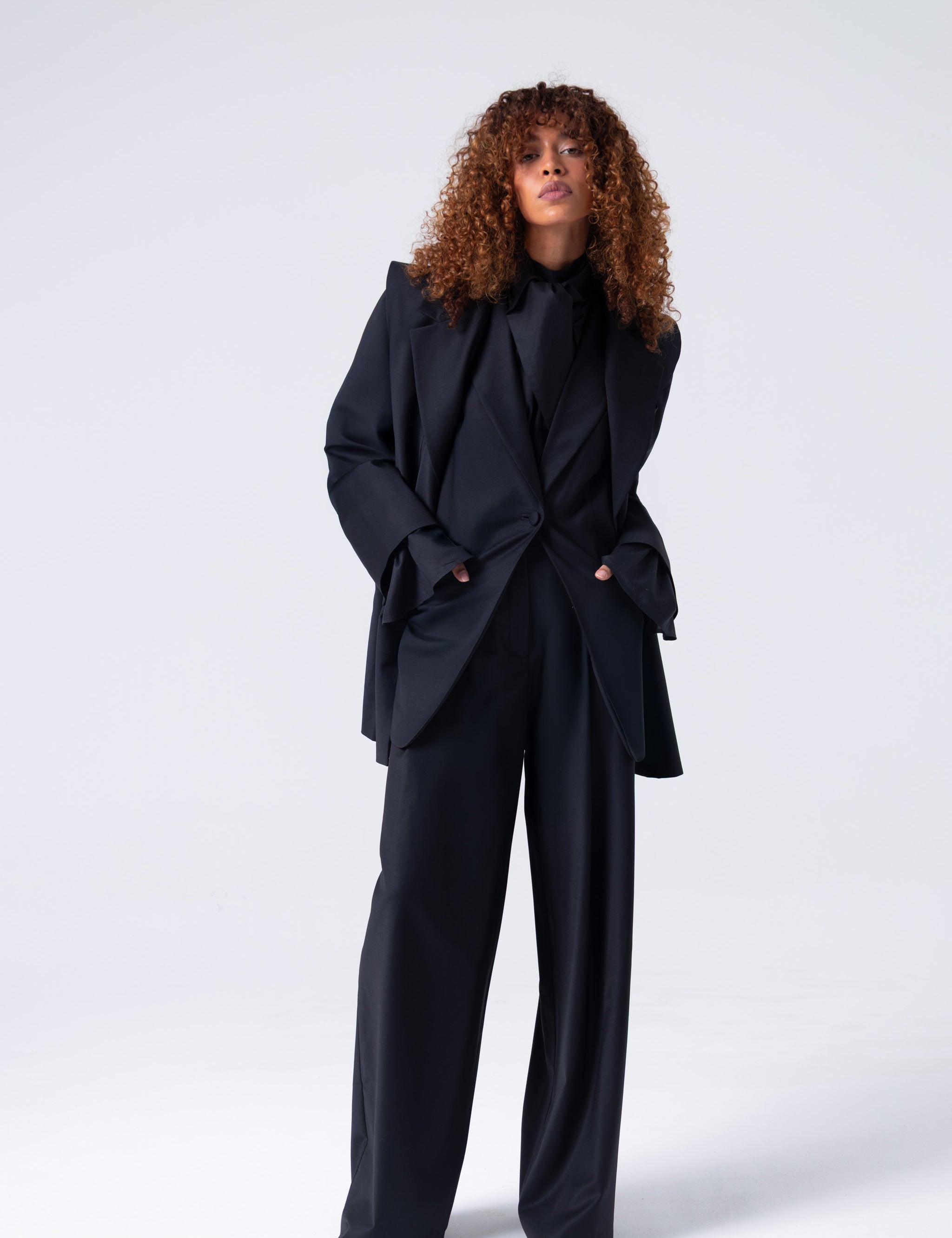 Person wearing a black suit on a white background