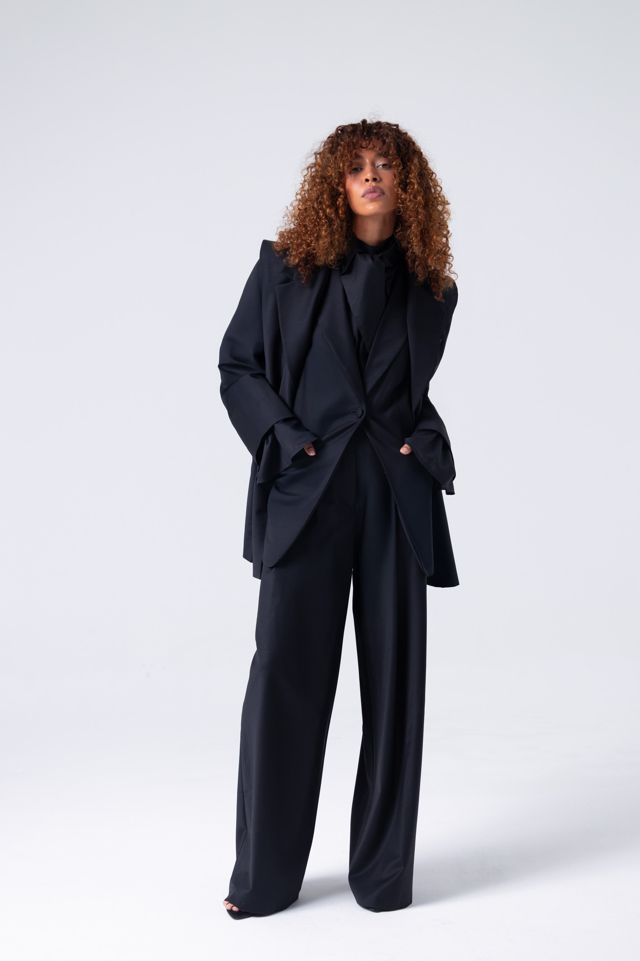 Person wearing a black suit on a white background