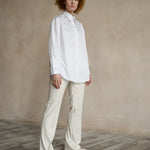 Relaxed-fit button-down shirt worn by a model with a curved hem and contemporary tailoring