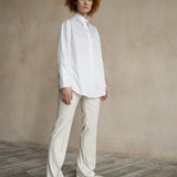 Relaxed-fit button-down shirt worn by a model with a curved hem and contemporary tailoring
