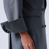 Gray blazer with a hand visible on a white background