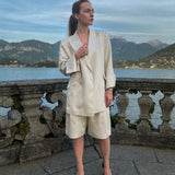 Linen-blend Bermuda shorts with front pleats and double belt loops, worn by a model on a Lake Como terrace