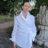 Luxury white asymmetric lapel collar shirt worn by a model, featuring an elegant wrap front and fluid drape