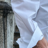 Close-up of a luxury white cotton three-button petal cuff on a shirt worn by a model