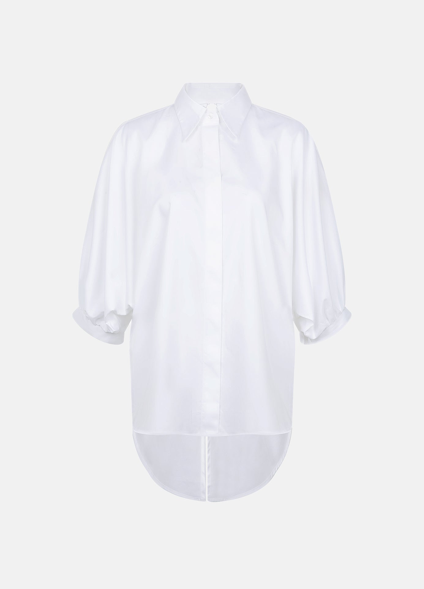 Organic cotton white shirt shown without a model, featuring puff sleeves, a curved hem and a concealed button placket