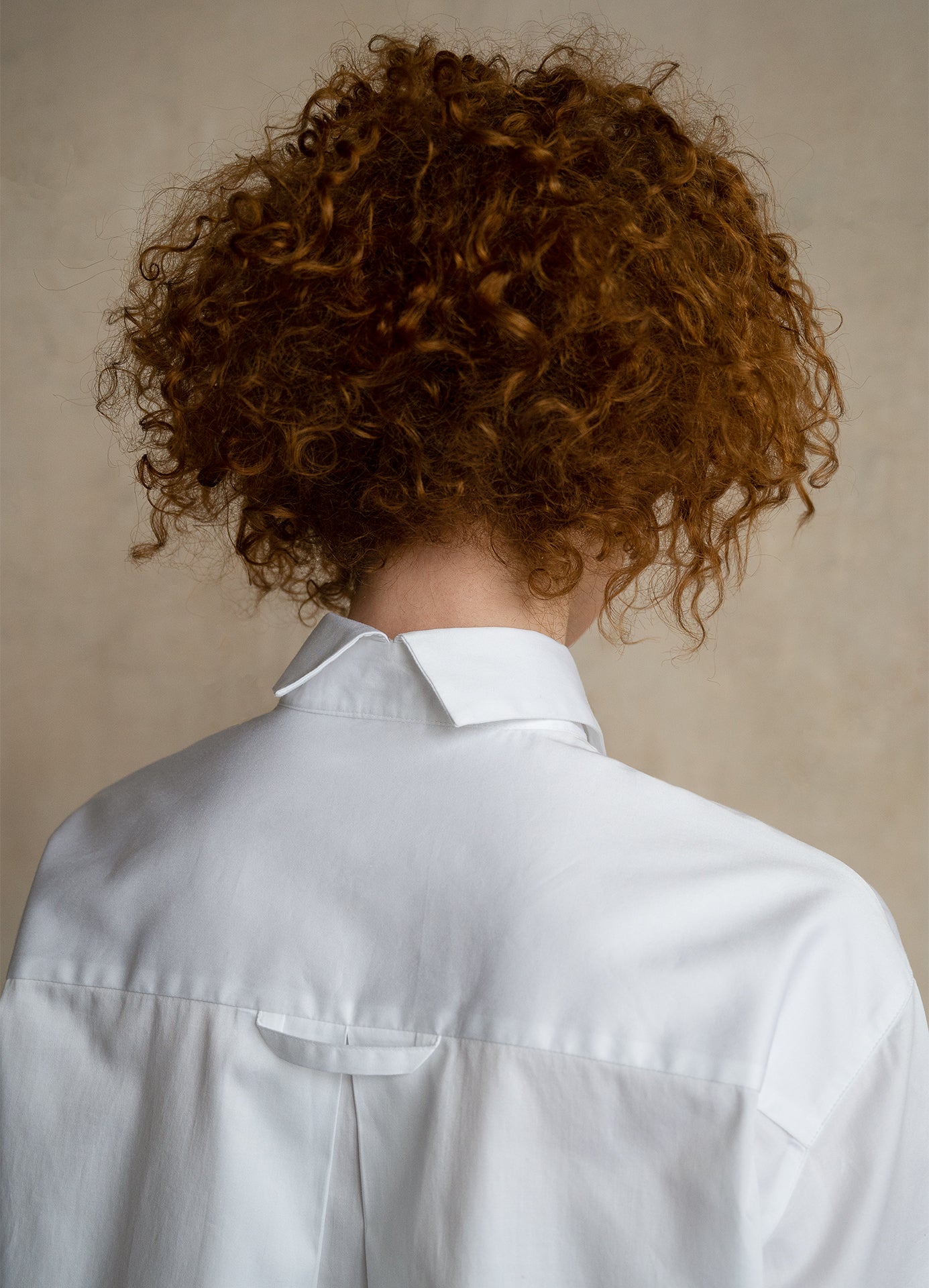 Close-up of the split-back collar on a premium designer button-down shirt worn by a model