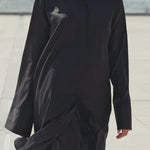 Black maxi shirt dress worn by a model walking outdoors, highlighting graceful movement and fluid drape