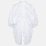 Prima white open-back shirt shown without a model from the back, revealing the drawstring construction