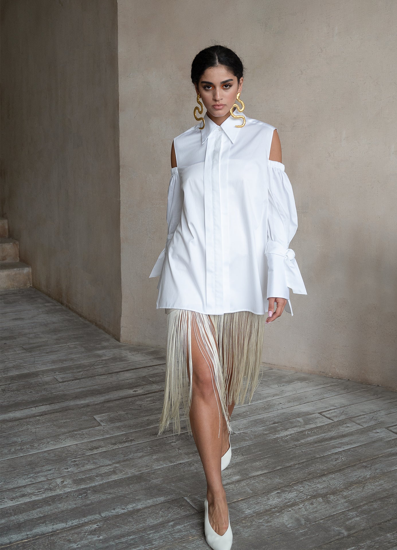 Relaxed-fit white cotton shirt with voluminous puff sleeves and cold-shoulder detailing, styled on a model