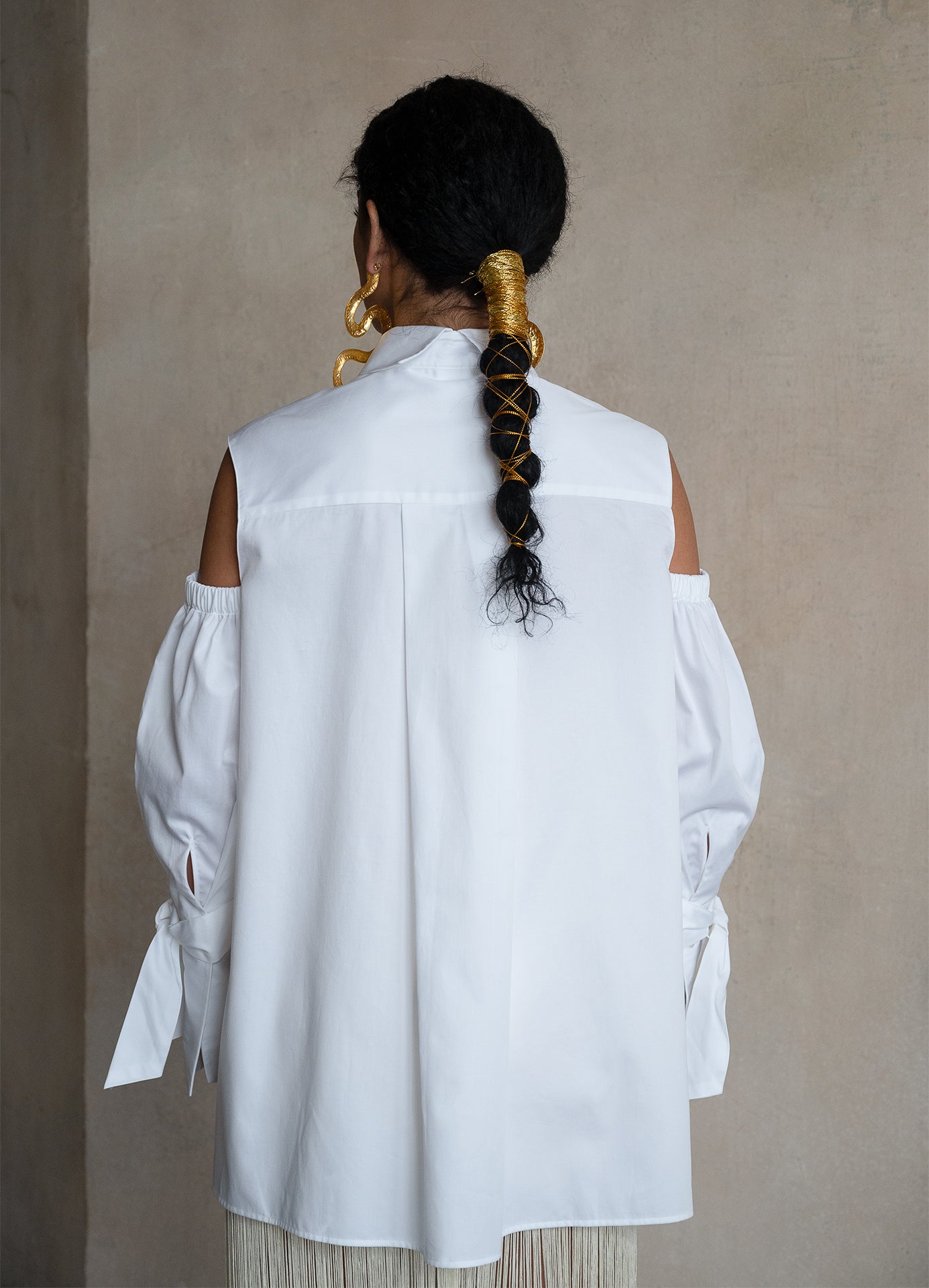 Split-back collar white cotton gabardine shirt with relaxed silhouette and cold-shoulder detailing, rear view on a model