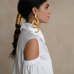White gabardine shirt with open-shoulder detail and sculptural puff sleeve, shown in side profile on a model