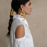White gabardine shirt with open-shoulder detail and sculptural puff sleeve, shown in side profile on a model