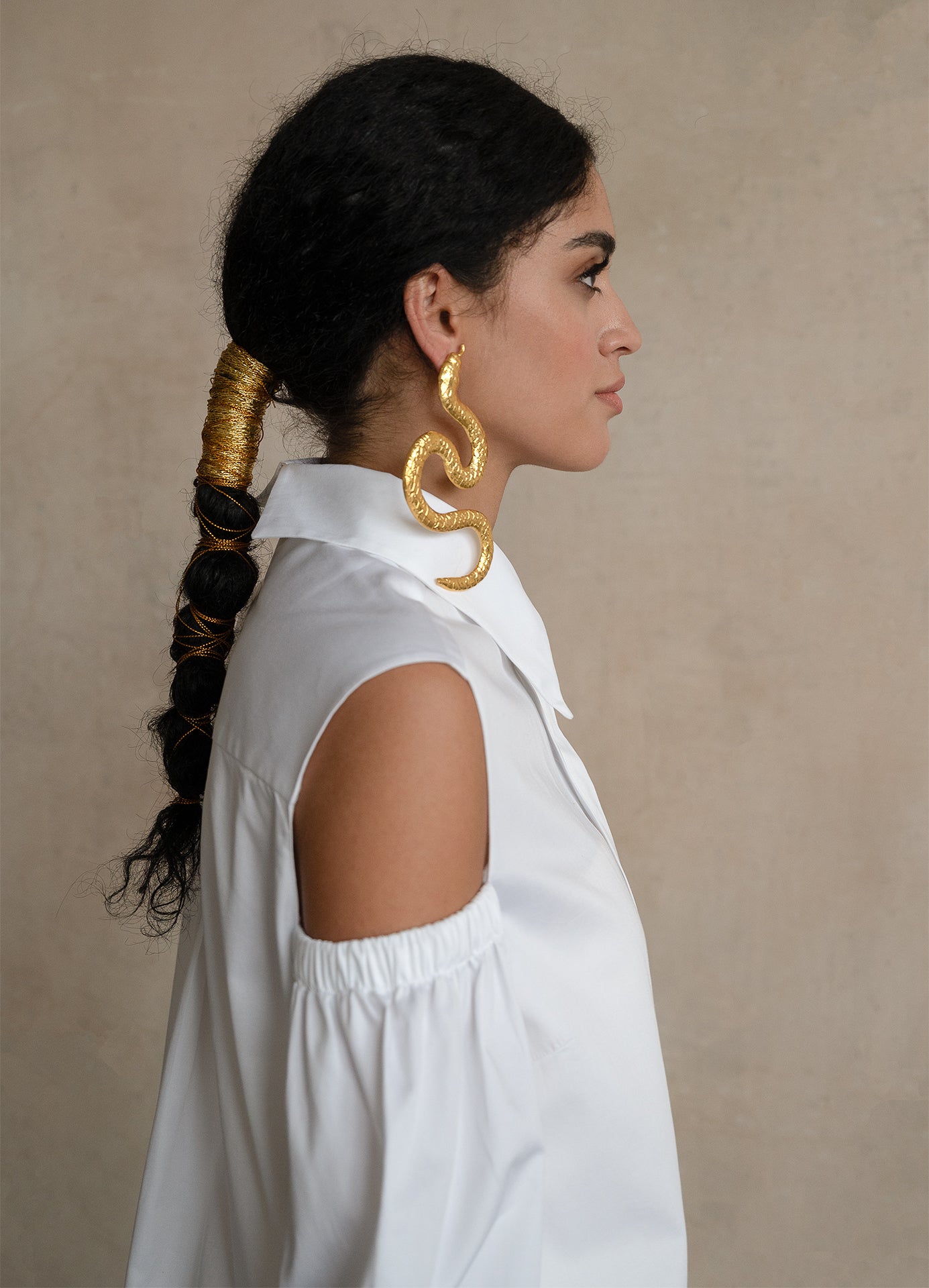 White gabardine shirt with open-shoulder detail and sculptural puff sleeve, shown in side profile on a model
