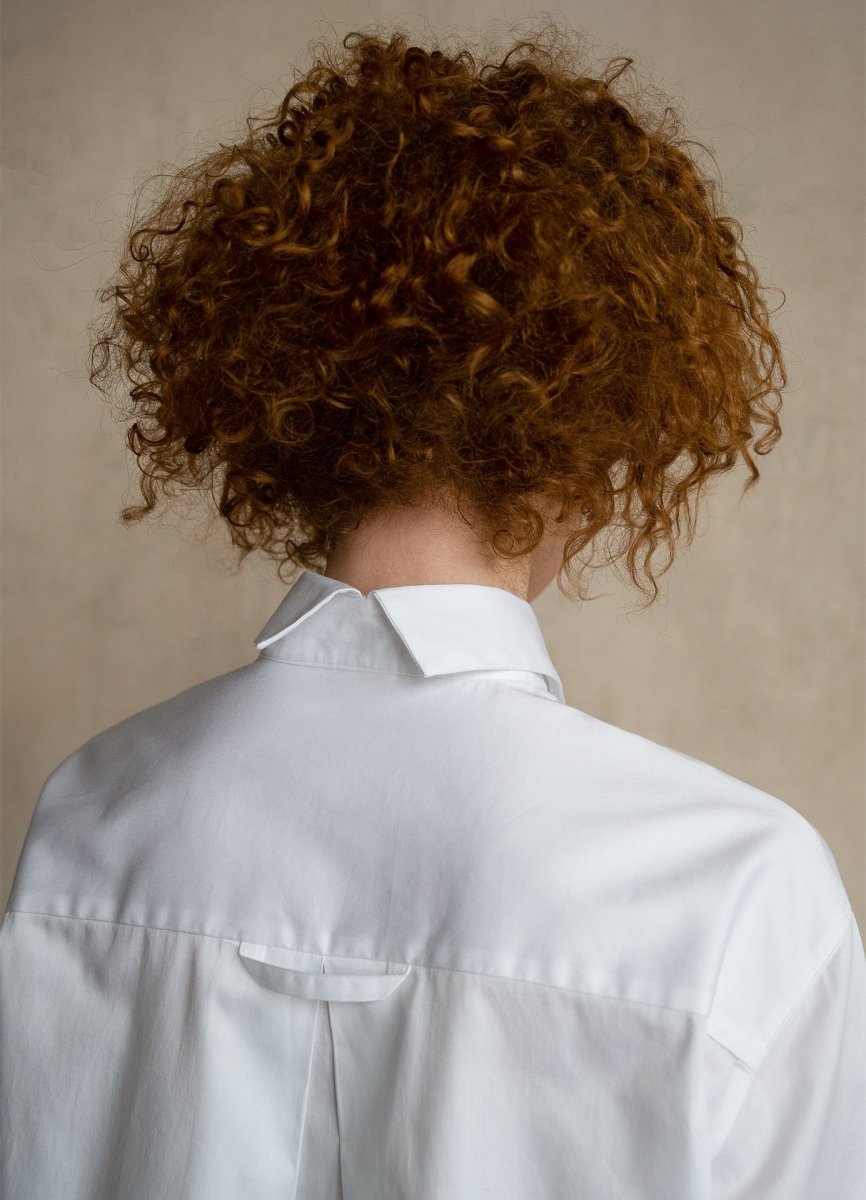 Woman in premium white business shirts close-up, with split collar and locker loop, back view