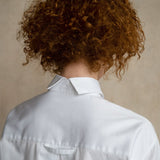 Woman in premium white business shirts close-up, with split collar and locker loop, back view