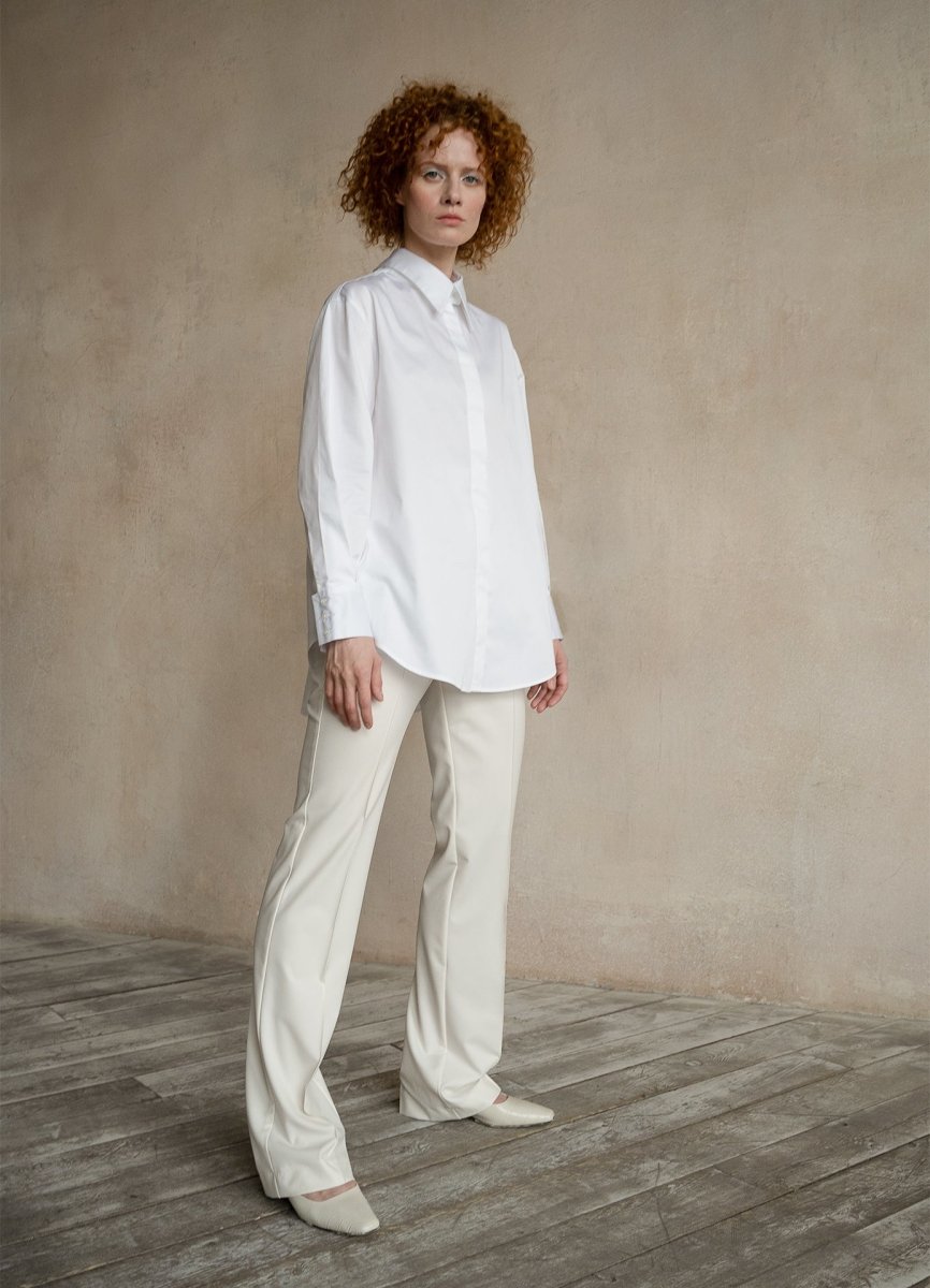 Woman in white shirt standing full length confidently, looking forward, front view